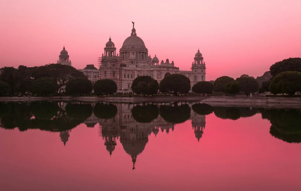 This image captures a sunset view of the Victoria Memorial in Kolkata, a iconic marble monument dedicated to Queen Victoria. 