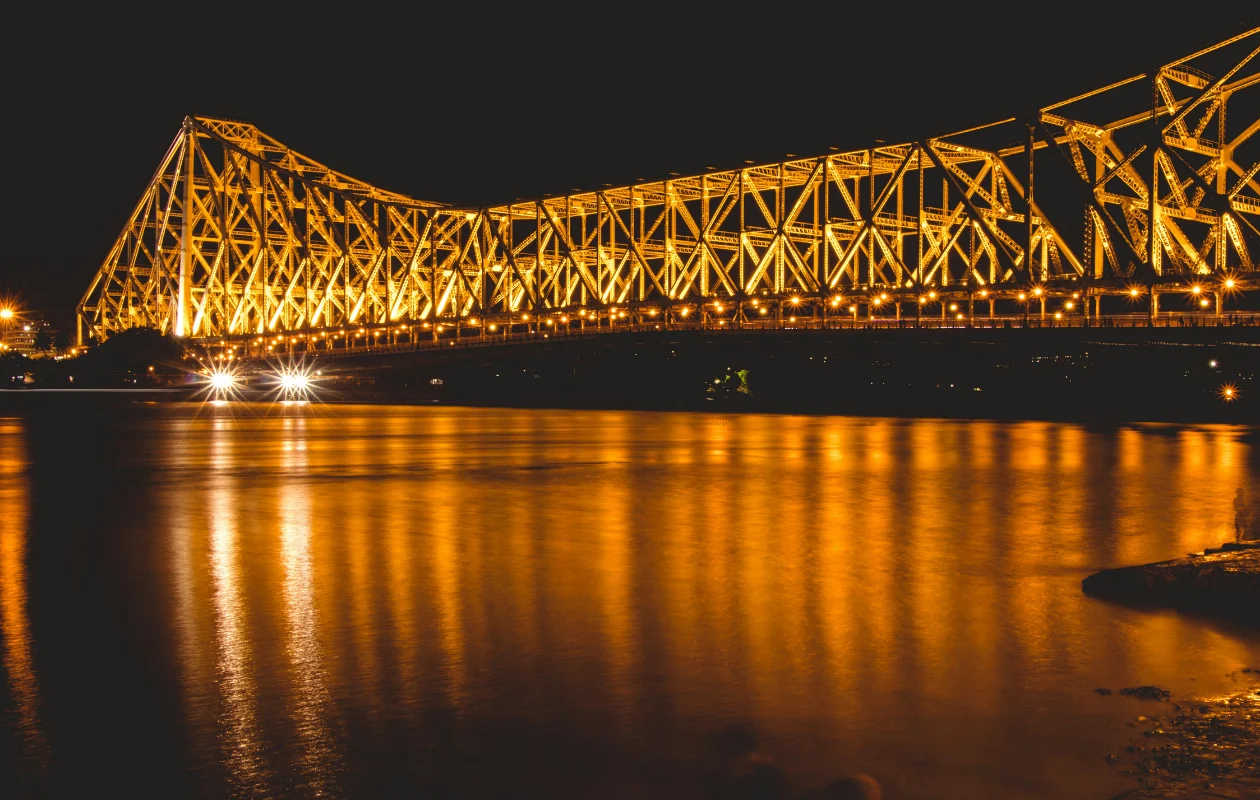 This image captures a nighttime view of the iconic Howrah Bridge, formally known as Rabindra Setu, in Kolkata, West Bengal.