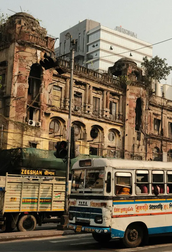 This image depicts a scene on Chowringhee Road (officially Jawaharlal Nehru Road) in Kolkata, showcasing the city's blend of colonial history and modern development. 