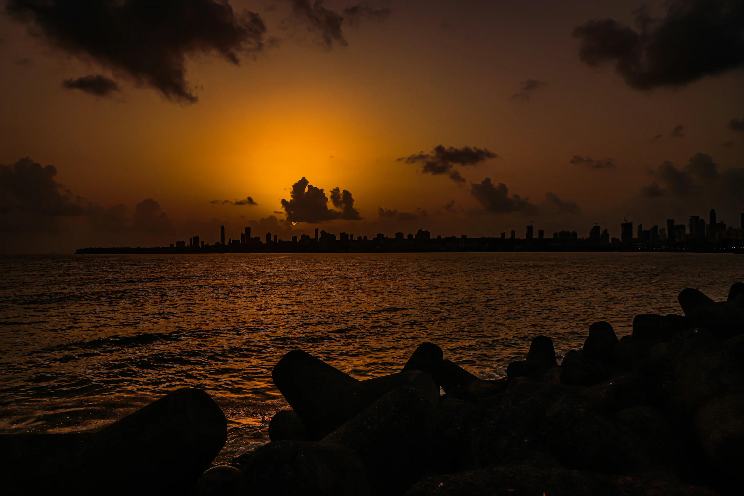 This image captures the sunset over Marine Drive in Mumbai, a famous coastal boulevard known as the "Queen's Necklace" due to its string of lights at night.